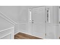 Inviting entryway featuring wood flooring, white trim, and a stylish front door at 522 Crossview Ln, Durham, NC 27703