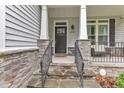 Inviting front entrance with stone accents, iron railing, and a black front door at 5412 Robbins Dr, Raleigh, NC 27610