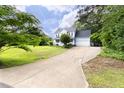 Traditional home with a long driveway and attached garage, surrounded by mature trees and landscaping at 59 Troy Dr, Fuquay Varina, NC 27526