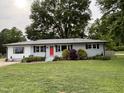 A single-story home with a vibrant red door and well-maintained lawn offers cozy curb appeal at 704 S Mineral Springs Rd, Durham, NC 27703
