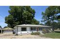 View of the home and detached garage with a well-maintained lawn, and beautiful, mature trees at 704 S Mineral Springs Rd, Durham, NC 27703