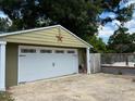 A detached garage with a white door, accented by a star decoration and partial fencing at 704 S Mineral Springs Rd, Durham, NC 27703