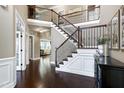 Elegant foyer featuring a grand staircase, hardwood floors, and natural lighting at 713 Liberty Cliff Dr, Cary, NC 27519
