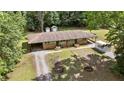 Aerial shot showcasing the duplex, mature trees, driveways, outbuildings, and a PODS moving container at 725-727 Locust Ln, Raleigh, NC 27603