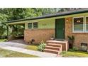 Inviting front entrance of unit 725 with brick steps, a secure door, and a covered carport at 725-727 Locust Ln, Raleigh, NC 27603