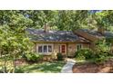 Inviting home with a red front door, surrounded by lush greenery and a neatly landscaped yard at 7918 Yester Ct, Raleigh, NC 27615