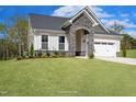 Charming two-story home with stone accents, attached two-car garage, and a well-maintained lawn at 87 Addison Pond Ct # 12, Zebulon, NC 27597