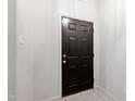 Classic black front door with tile flooring in the entryway at 1000 Brighthurst Dr # 104, Raleigh, NC 27605