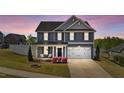 Charming two-story home with blue siding and a manicured front yard at dusk at 1002 Addington Lake Ln, Knightdale, NC 27545