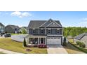 Beautiful two-story home with blue siding, white trim, inviting porch, and two-car garage at 1002 Addington Lake Ln, Knightdale, NC 27545