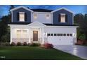 Charming two-story home with a two-car garage, beautiful landscaping, and a welcoming front porch at 1124 Landen Creek Ln, Zebulon, NC 27597
