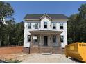Two-story home featuring a charming front porch, brick foundation, and large windows under construction in a wooded area at 116 Legolas Ct, Middlesex, NC 27557