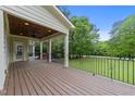 Spacious back deck featuring wood flooring, a ceiling fan, and a view of the lush backyard at 12217 Beestone Ln, Raleigh, NC 27614