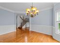 Spacious dining room features hardwood floors, wainscoting, chandelier and views of the staircase at 12217 Beestone Ln, Raleigh, NC 27614