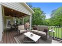 Inviting covered porch with elegant furniture and scenic backyard view at 12217 Beestone Ln, Raleigh, NC 27614