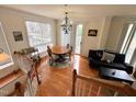 Cozy living room featuring hardwood floors, large windows, and a chandelier at 1230 Capability Dr # 106, Raleigh, NC 27606