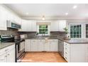 Bright kitchen featuring white cabinets, gray countertops, stainless steel appliances, and natural lighting at 12709 Timberlane Ct, Raleigh, NC 27613