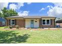 Charming brick home with a well-maintained lawn and a light blue front door, perfect for a cozy feel at 1422 Duggins Dr, Burlington, NC 27217