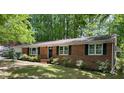 Traditional brick ranch home with a well manicured front yard and a black front door at 1713 S Garnett St, Henderson, NC 27536