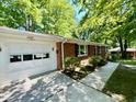 Side view of brick ranch home with an attached white two car garage at 1713 S Garnett St, Henderson, NC 27536