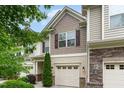 Charming townhouse features a tan exterior with brown accents, a one-car garage and manicured landscaping at 172 Token House Rd, Durham, NC 27703