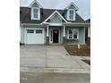 Inviting new construction showcasing green siding, one-car garage, and a concrete driveway at 1739 Old Fields Blvd, Haw River, NC 27258