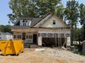 New construction featuring vertical siding and a visible ladder for access to the unfinished second level at 218 Oakdale Ave, Clayton, NC 27520