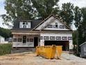 Exterior view of new construction home featuring a black roof and gray brick along the foundation at 218 Oakdale Ave, Clayton, NC 27520