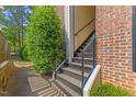 The side entrance of this townhome features well-maintained stairs and vibrant green bushes at 2201 Mountain Mist Ct # 202, Raleigh, NC 27603
