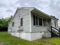 Side view of a single-story home featuring horizontal siding and lawn at 246 Keene St, Henderson, NC 27536