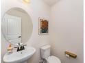 Cozy half bathroom with a modern sink, mirror, and decorative wall art at 2530 Girvan Dr, Fuquay Varina, NC 27526