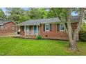 Classic brick house with a pop of color from the blue front door and well-maintained landscaping at 307 Pine Tree Rd, Oxford, NC 27565