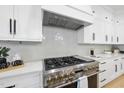 Close up of kitchen details featuring stainless steel oven and range with white stone backsplash at 3407 Churchill Rd, Raleigh, NC 27607