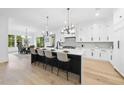 Open kitchen featuring a large island with seating, modern lighting, and a bright dining area at 3407 Churchill Rd, Raleigh, NC 27607