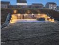 Backyard patio featuring a stylish stone fire pit with built-in seating and outdoor lighting at 400 Access Dr, Youngsville, NC 27596