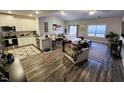 Open-concept living room featuring hardwood floors, modern decor, and an adjacent kitchen with granite countertops at 400 Access Dr, Youngsville, NC 27596
