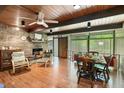 Spacious living room featuring a stone fireplace, wood ceiling, large windows and an open dining area at 4501 Zebulon Rd, Zebulon, NC 27597