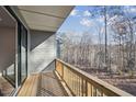 Balcony with wood flooring and railing overlooking a wooded area at 4607 Mint Leaf Ln, Raleigh, NC 27612