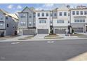 Exterior view of modern townhomes with gray siding, multi-pane windows, and garages at 4607 Mint Leaf Ln, Raleigh, NC 27612
