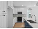 A spacious kitchen with white cabinets, stainless appliances and light hardwood floors at 5049 Lundy Dr # 101, Raleigh, NC 27606
