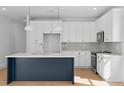 Kitchen with a large island, white cabinets, stainless steel appliances and modern finishes at 5049 Lundy Dr # 101, Raleigh, NC 27606