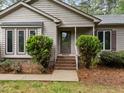 Close-up of front entrance with decorative shrubbery, stairs and modern door at 5109 Knaresborough Rd, Raleigh, NC 27612