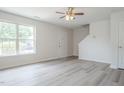 Bright living room with gray flooring, a large window, and fresh white paint at 5522 Marthonna Way, Raleigh, NC 27616