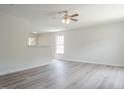 Open-concept living area featuring modern gray floors, neutral walls, and a ceiling fan at 5522 Marthonna Way, Raleigh, NC 27616