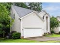 View of the home's vinyl siding, two-car garage, and well-manicured lawn at 5629 Yates Garden Ln, Raleigh, NC 27606