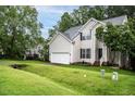 Well-manicured front yard and two-story home with vinyl siding and attached garage at 5629 Yates Garden Ln, Raleigh, NC 27606