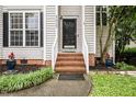 Home's entrance with brick steps and a black front door, complete with fresh landscaping at 5629 Yates Garden Ln, Raleigh, NC 27606