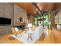 Bright living room boasting a brick fireplace, hardwood floors, wood ceiling, and an abundance of natural light at 612 Greenwood Rd, Chapel Hill, NC 27514