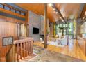 Open-concept living room with beautiful stone floor entry, hardwood floors, wood ceilings and a brick fireplace at 612 Greenwood Rd, Chapel Hill, NC 27514