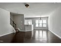 Open-concept living area featuring hardwood floors, neutral walls, and staircase to the upper level at 628 Denhoff Dr, Cary, NC 27519